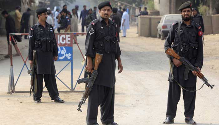 Police personnel in Khyber Pakhtunkhwa stand guard near a barricade on a road. — Reuters/File