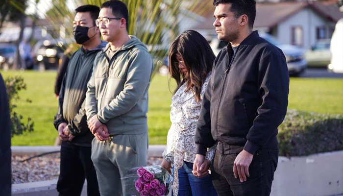 22 جنوری 2023 کو مونٹیری پارک، کیلیفورنیا میں چینی نئے سال کے جشن کے دوران ہونے والی شوٹنگ کے جائے وقوعہ کے قریب کمیونٹی کے اراکین نماز کے لیے اکٹھے ہوتے ہیں۔— رائٹرز