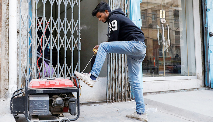 A man starts a generator outside his shop during a country-wide power breakdown in Karachi, Pakistan January 23, 2023. — Reuters