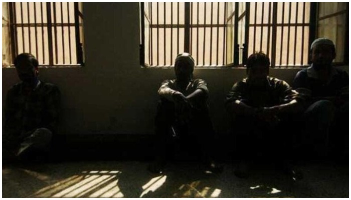 The picture shows silhouettes of people sitting in a room. — AFP