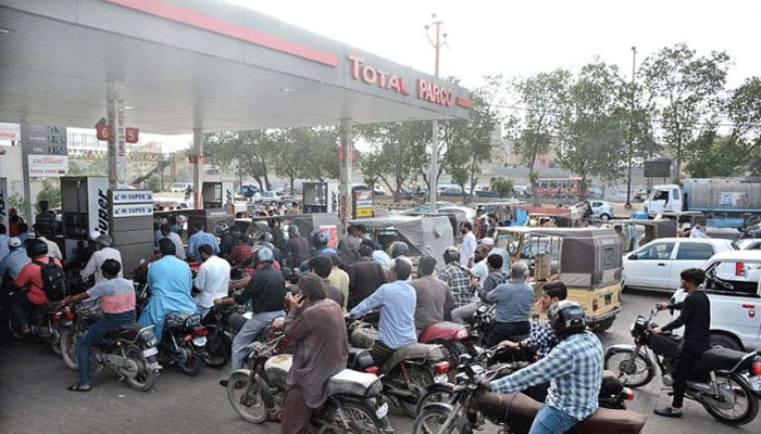 Motorcyclists wait in a line at a petrol pump in Karachi. — APP/File