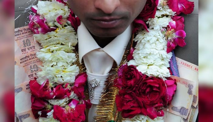 A groom with a garland made of notes. — AFP/File