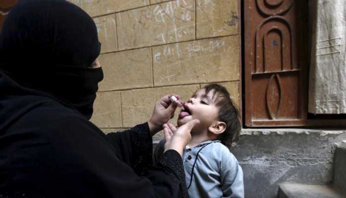 A boy receives polio vaccine drops outside his family home in Karachi, February 15, 2016. — Reuters