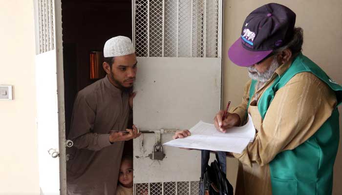 A census enumerator notes details from a resident during Pakistan’s 6th population census in Karachi, March 15, 2017. — Reuters