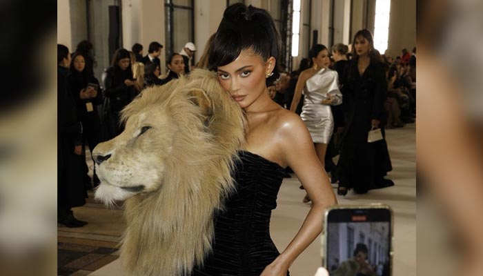 Kylie Jenner poses with a giant lion head attached to her dress at the Schiaparelli Haute Couture Spring/Summer 2023 show on January 23, 2023. — Twitter