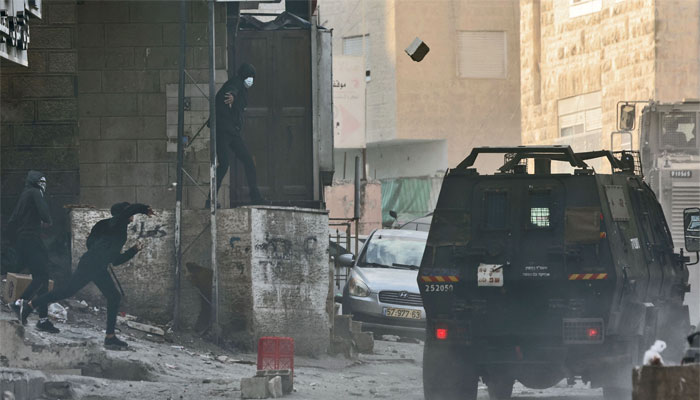 Israeli security forces clash with Palestinians in east Jerusalems Shuafat refugee camp on January 25, 2023, following an operation to destroy the interior of a 6th-floor flat belonging to a Palestinian man suspected of a deadly attack against Israeli forces. — AFP