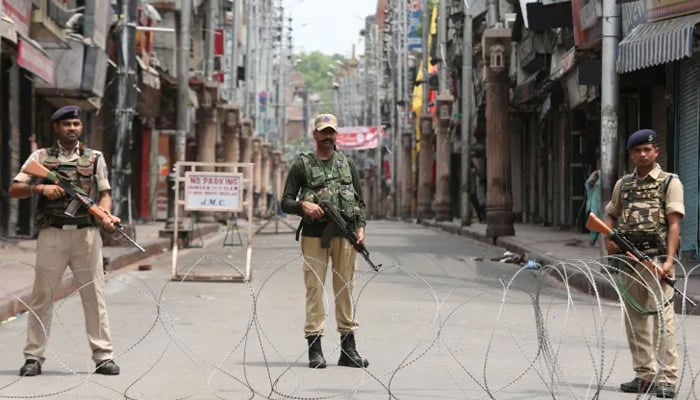 Indian security personnel stand guard along a deserted street during restrictions in occupied Jammu. — Reuters/File