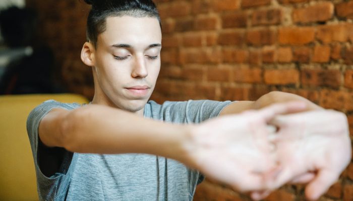 Male teen with closed eyes cracking knuckles.— Pexels