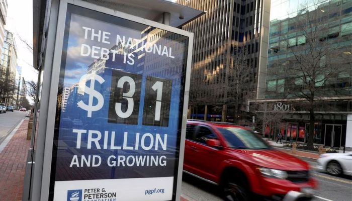 A car drives next to a board at a bus stop showing a US national debt figure after the government hit its $31.4 trillion borrowing limit amid a standoff between the Republican-controlled House of Representatives, President Joe Biden and Democratic legislators that could lead to a fiscal crisis in a few months, in Washington, January 20, 2023.— Reuters