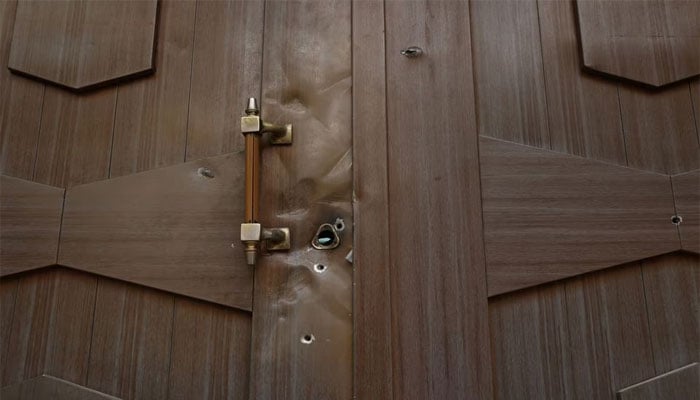 A view shows bullet holes in a door after an attack at the embassy. — Reuters