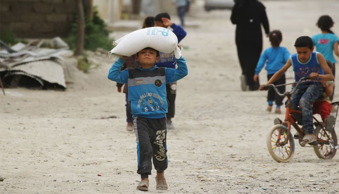 A boy carries food aid given by the UNs World Food Programme in Raqqa, Syria. — Reuters/File