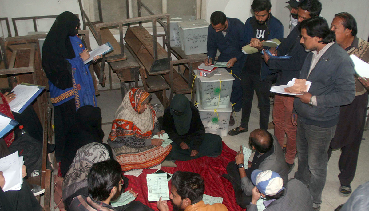 Election officials count ballots after polls closed at a polling station during an election in Karachi on January 15, 2023. — Online