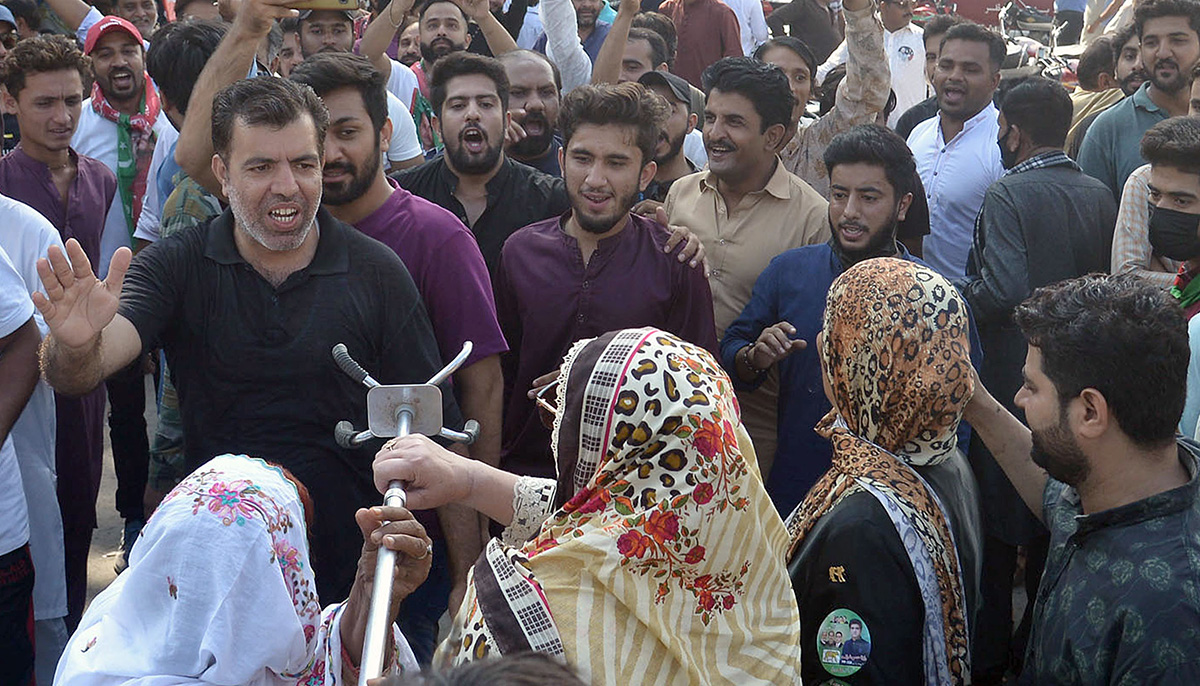 A view of a clash between political parties supporters outside a polling station during by-election of PP-158 in Lahore on July 15, 2022. — Online