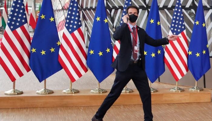 A security guard walks near EU and US flags, before the EU-US summit, in Brussels, Belgium June 15, 2021.— Reuters