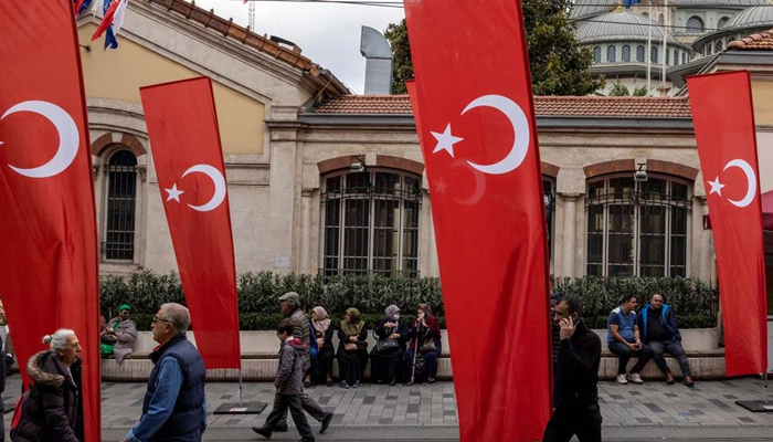 People walk along Istiklal Avenue, decorated with Turkish national flags after Sundays blast killed six and wounded dozens, in Istanbul, Turkey, November 14, 2022.— Reuters