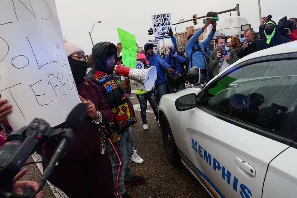 People protest next to a police car after the release of the body cam footage showing police officers beating Tyre Nichols, the young Black man who died three days after he was pulled over while driving during a traffic stop by Memphis police officers, in downtown Memphis, Tennessee, U.S., January 28, 2023.— Reuters