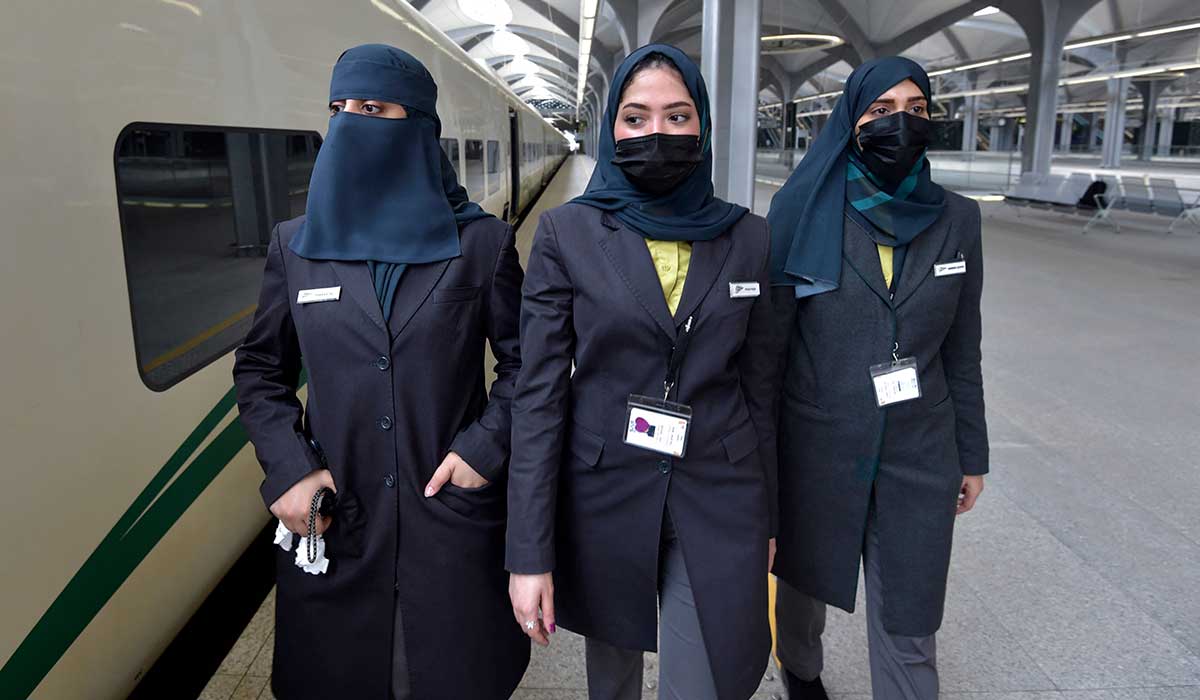 Saudi conductors walk beside the high-speed. — AFP