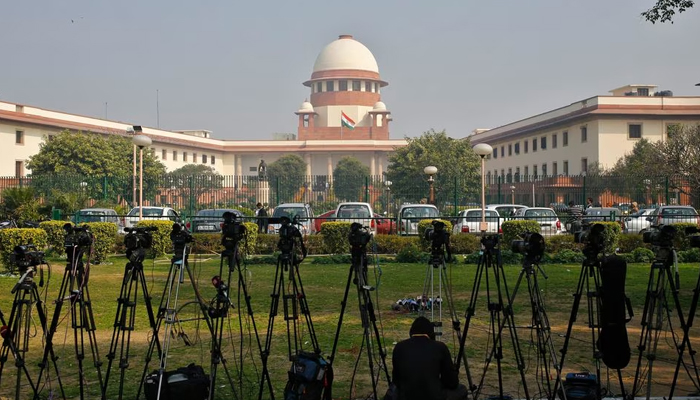 A television journalist sets his camera inside the premises of the Supreme Court in New Delhi February 18, 2014.— Reuters