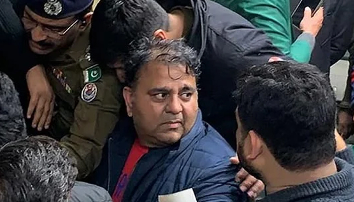 Police officials escort the arrested leader of opposition Pakistan Tehreek-e-Insaf (PTI) party, Fawad Chaudhry (C) to present him before a court in Lahore on January 25, 2023. — AFP