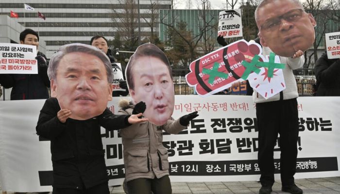 Anti-war activists in Seoul hold images of South Korean President Yoon Suk-yeol (C), Defense Minister Lee Jong-sup (L) and US Secretary of Defense Lloyd Austin.— AFP/file