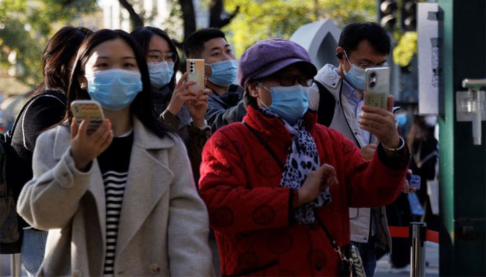 People scan their health codes before entering a fenced-off street as outbreaks of the coronavirus disease (COVID-19) continue in Beijing, China. — Reuters/File