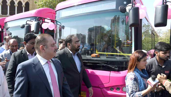 Sindh Information and Transport Minister Sharjeel Memon walks in front of Pink Buses at the inauguration ceremony in Karachi on February 1, 2023. — Online