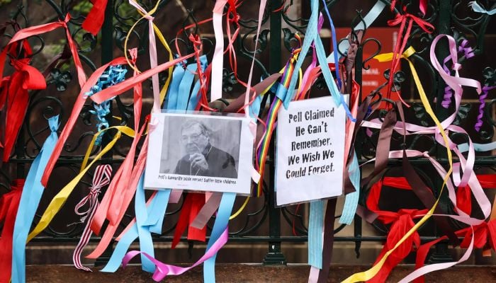 Ribbons and banners placed by protesters hang from the fence surrounding St Marys Cathedral in Sydney, where the body of Catholic Cardinal George Pell lay in state on February 1, 2023.— AFP
