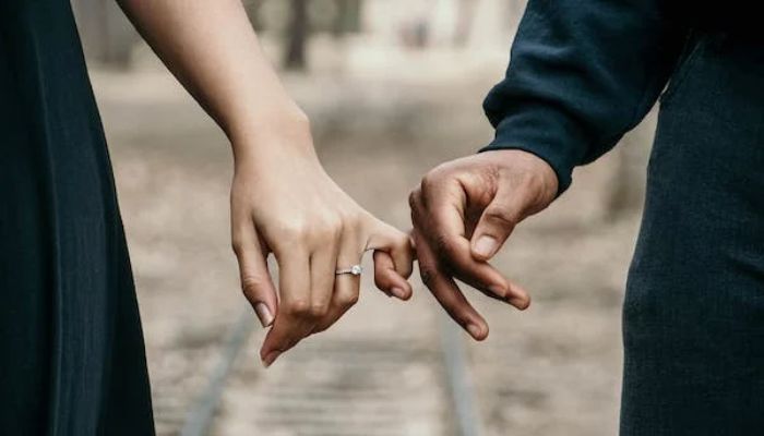 Man in black long-sleeved shirt holding the hand of a woman.— Pexels