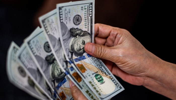 A person shows US dollars at a currency exchange store. — Reuters/File