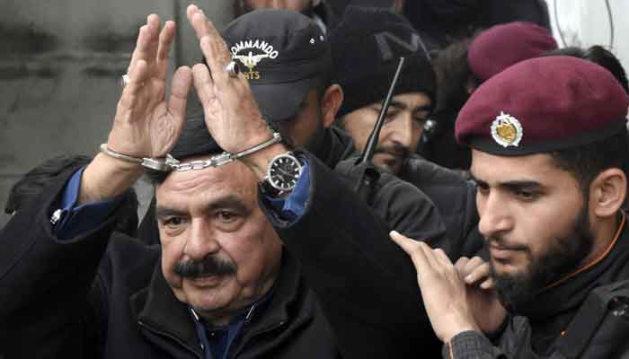 Police officials escort former interior minister Shiekh Rashid as he arrives to attend hearing at additional and sessions court in Federal Capital. — ONLINE