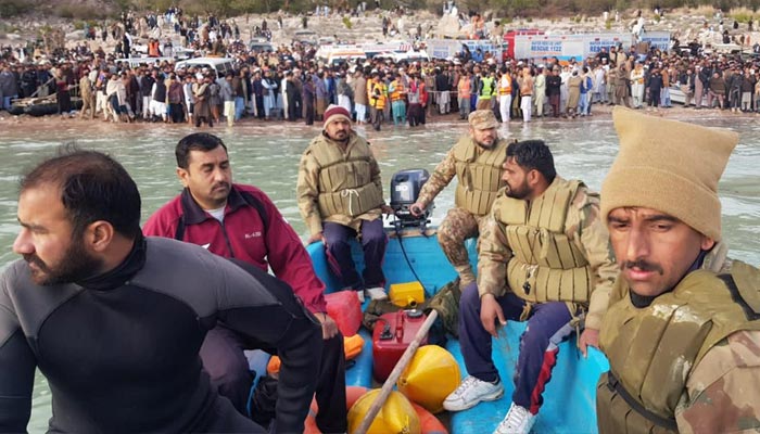 Army divers during the rescue mission on Tanda Dam, as onlookers watch. — ISPR