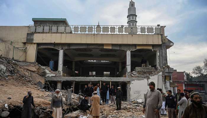 1 فروری 2023 کو پشاور میں پولیس ہیڈ کوارٹر کے اندر 30 جنوری کو ہونے والے خودکش دھماکے کے بعد ایک تباہ شدہ مسجد کے ملبے پر جمع ہوتے ہوئے سادہ لباس والے پولیس اہلکار جائے وقوع کا معائنہ کر رہے ہیں۔ — اے ایف پی
