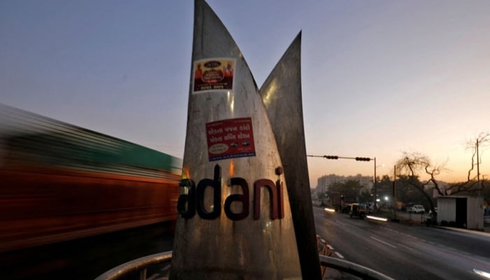 Traffic moves past the logo of the Adani Group installed at a roundabout on the ring road in Ahmedabad, India, February 2, 2023. — Reuters