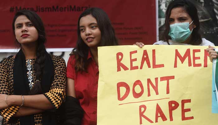 A demonstrator holds a placard next to others during a protest against an alleged gangrape of a woman, in Karachi. — AFP/File