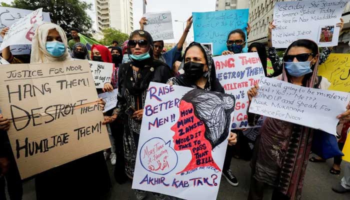 People carry signs against killing of Noor Mukadam, daughter of former diplomat, and condemn the violence against women and girls during a protest in Karachi, July 25, 2021. — Reuters