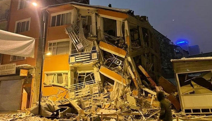 A man walks past a collapsed building after an earthquake in Malatya. — Reuters.
