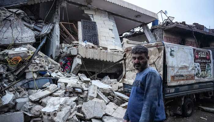 A resident stands in front of a collapsed building following an earthquake in the town of Jandaris, in the countryside of Syrias northwestern city of Afrin in the rebel-held part of Aleppo province, on February 6, 2023. — AFP
