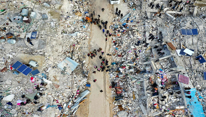 Aerial view shows residents searching for victims and survivors amidst the rubble of collapsed buildings in Syrias Idlib province on the border with Turkey on February 6, 2023. — AFP