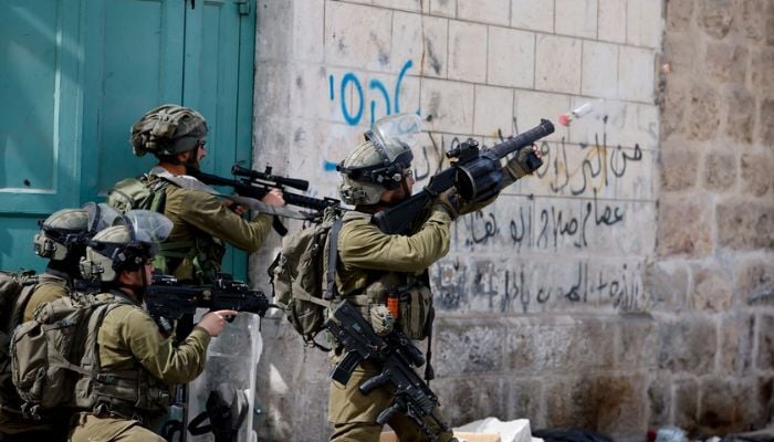An Israeli soldier uses a weapon amid clashes with Palestinian protesters, in Hebron, in the Israeli- occupied West Bank April 1, 2022.— Reuters
