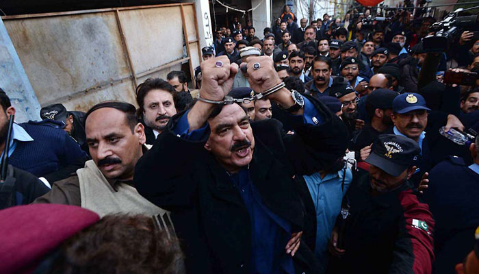 Former Interior Minister Sheikh Rashid Ahmed being escorted out of court by the police. — APP/File