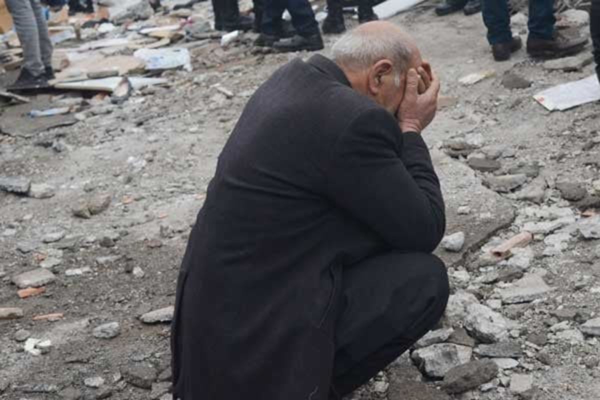 A man reacts as people search for survivors through the rubble in Diyarbakir, on February 6, 2023.— AFP