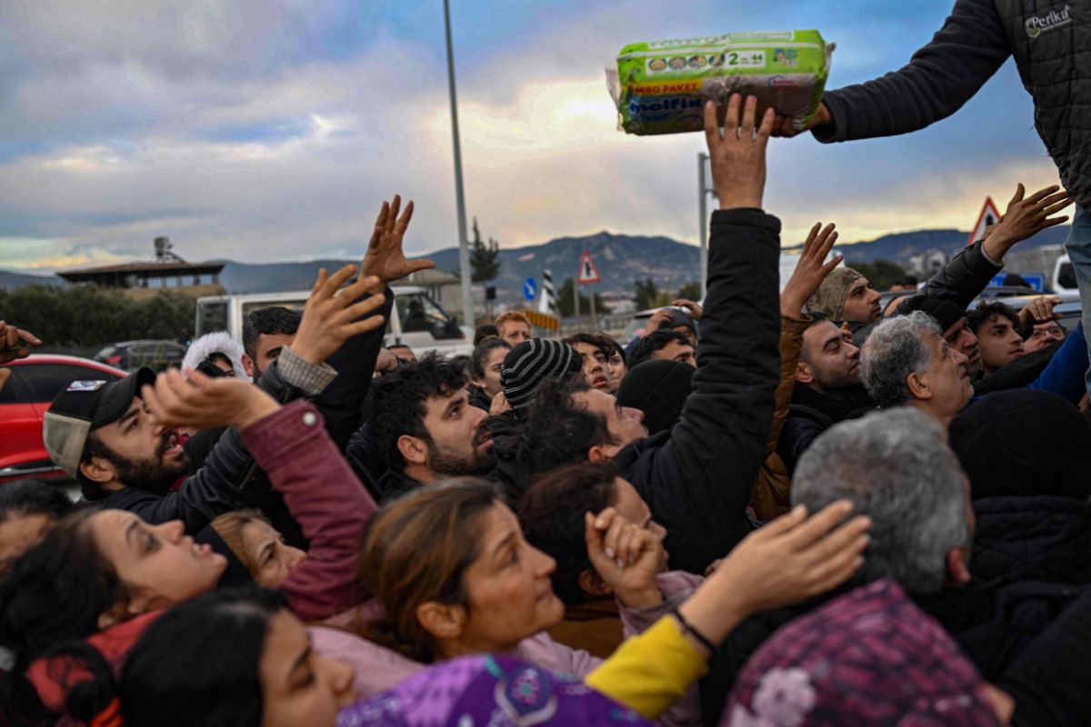 Earthquake survivors gather to collect supplies at a diaper distribution in Hatay on February 7. — AFP