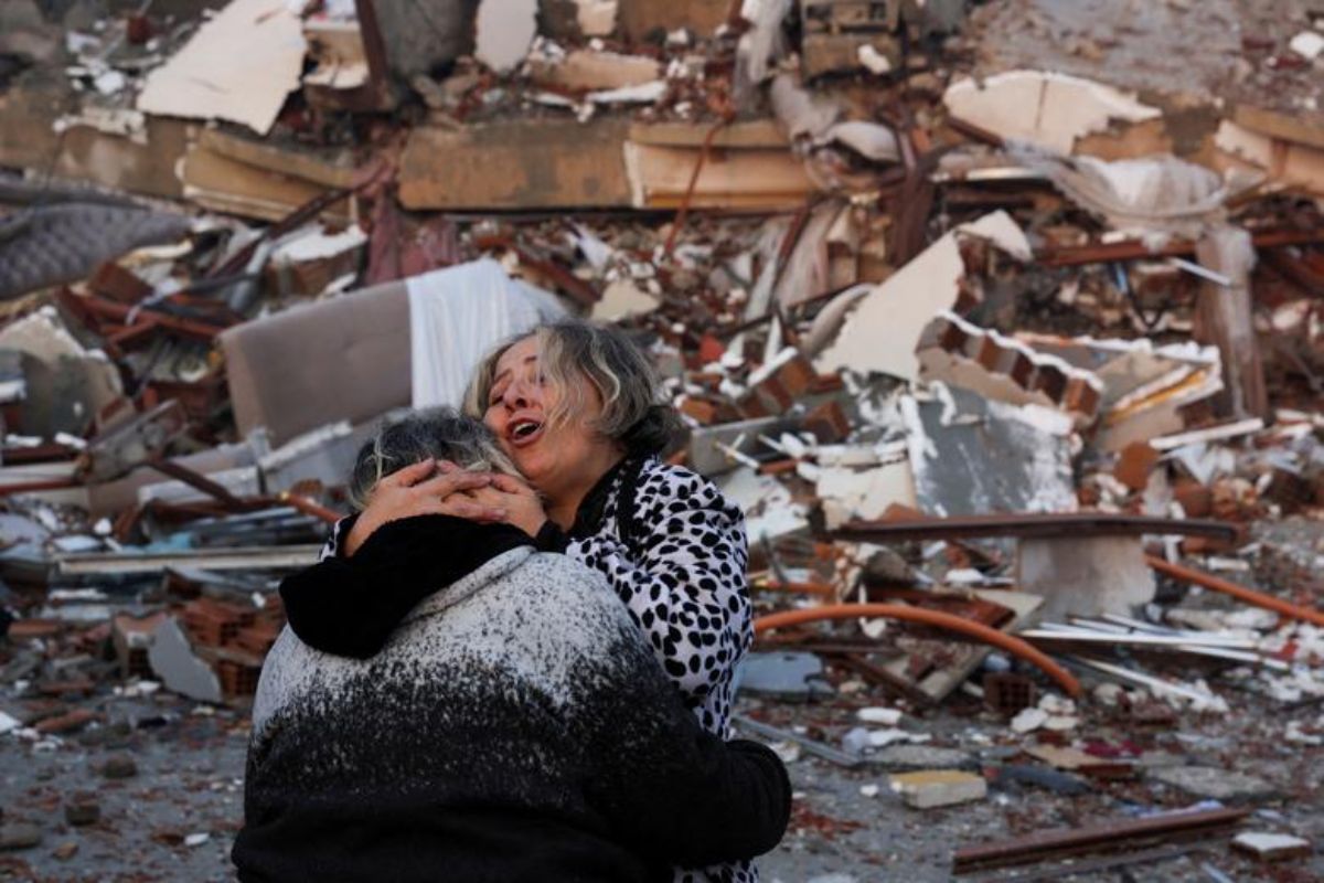 A woman reacts while embracing another person, near rubble in Hatay, Turkey, February 7.— Reuters