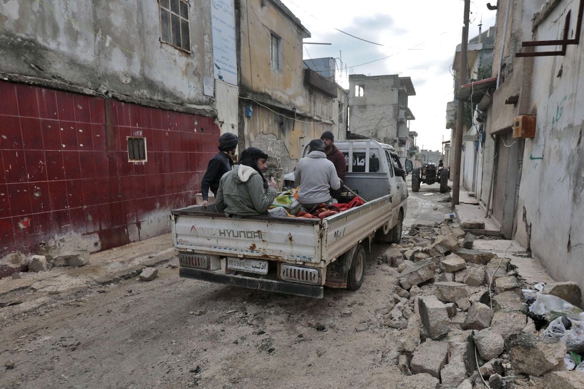 Syrian men transport casualties in the back of a pickup truck on February 7 in the town of Jandairis, in the rebel-held part of Aleppo province. — AFP