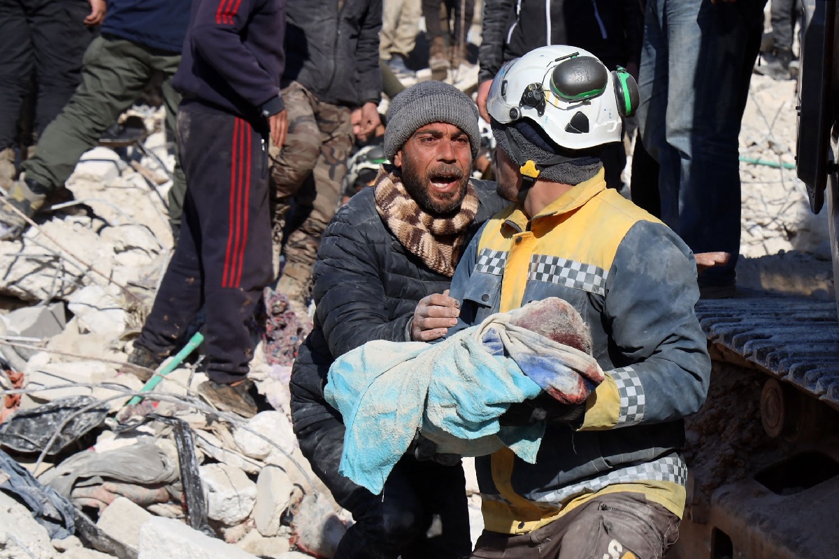 A man reacts as the body of his baby pulled out from the rubble, is taken away by a Syrian White Helmet rescue worker, in the town of Harim in Syria´s rebel-held northwestern Idlib province on the border with Turkey, on February 8, 2023.— AFP