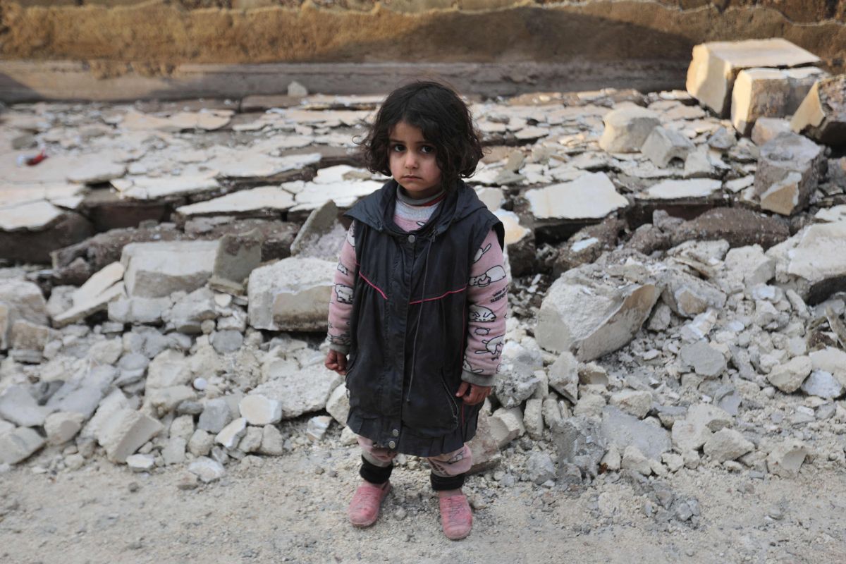 Syrian girl stands amidst debris from a collapsed building on February 7, 2023, in the town of Jandairis.— AFP