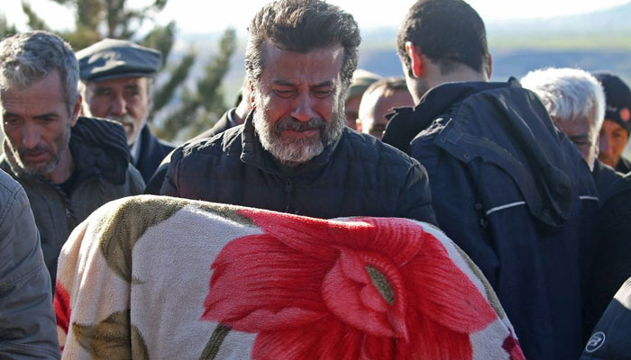 A man carries the body of child who was killed with his parents in a deadly earthquake, during a funeral in the village of Gozebasi in Adiyaman province, Turkey, February 9, 2023.— Reuters