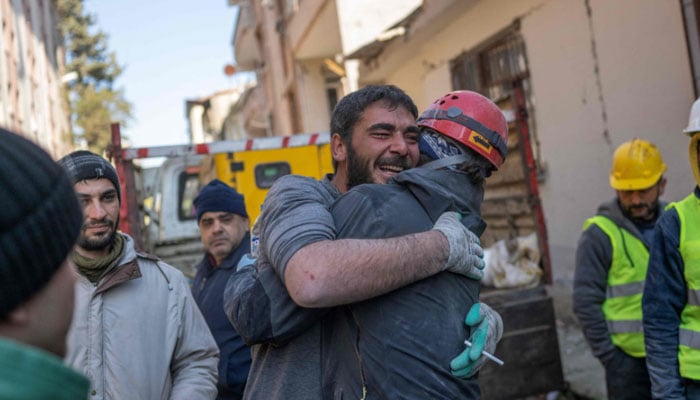 A miner (L), who rescued 16-year-old Melda after she was stuck for three days in rubble, reacts with a fellow rescue team member in Hatay, on February 9, 2023, three days after a 7,8-magnitude earthquake struck southeast Turkey. AFP