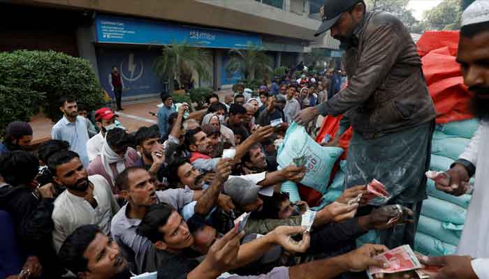 Men reach out to buy subsidised flour sacks from a truck in Karachi, Pakistan January 10, 2023. —Reutres/File