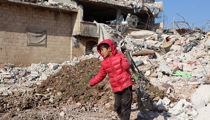 A child salvages a bicycle from the ruins of a building, as search and rescue operations continue days after a deadly earthquake hit Turkey and Syria, in the town of Jindayris, in the rebel-held part of Syrias Aleppo province, on February 10, 2023. — AFP